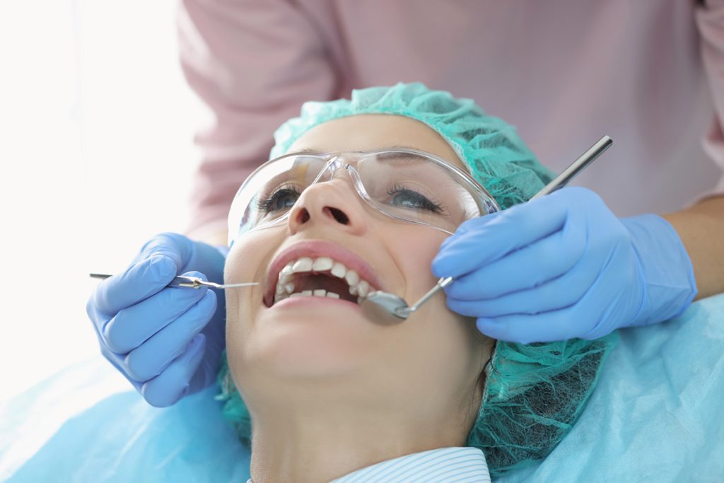 What Is a Periodontist? When to See One & How They Treat Gum Disease 1 Woman in a dentist chair, appointment with her periodontist.